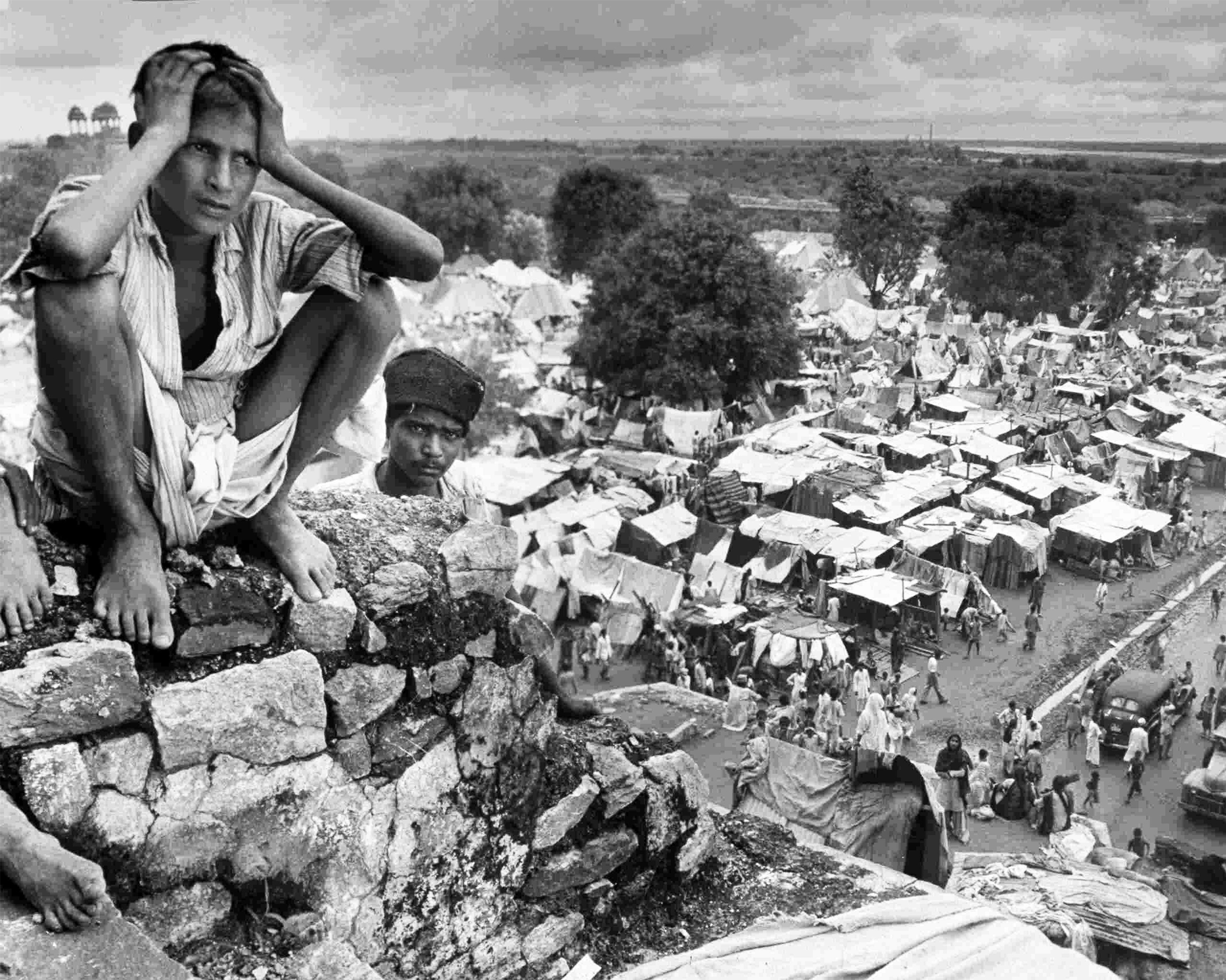A photo showing a boy sitting on the walls of a refugee camp in Delhi during the Partition of India in 1947.