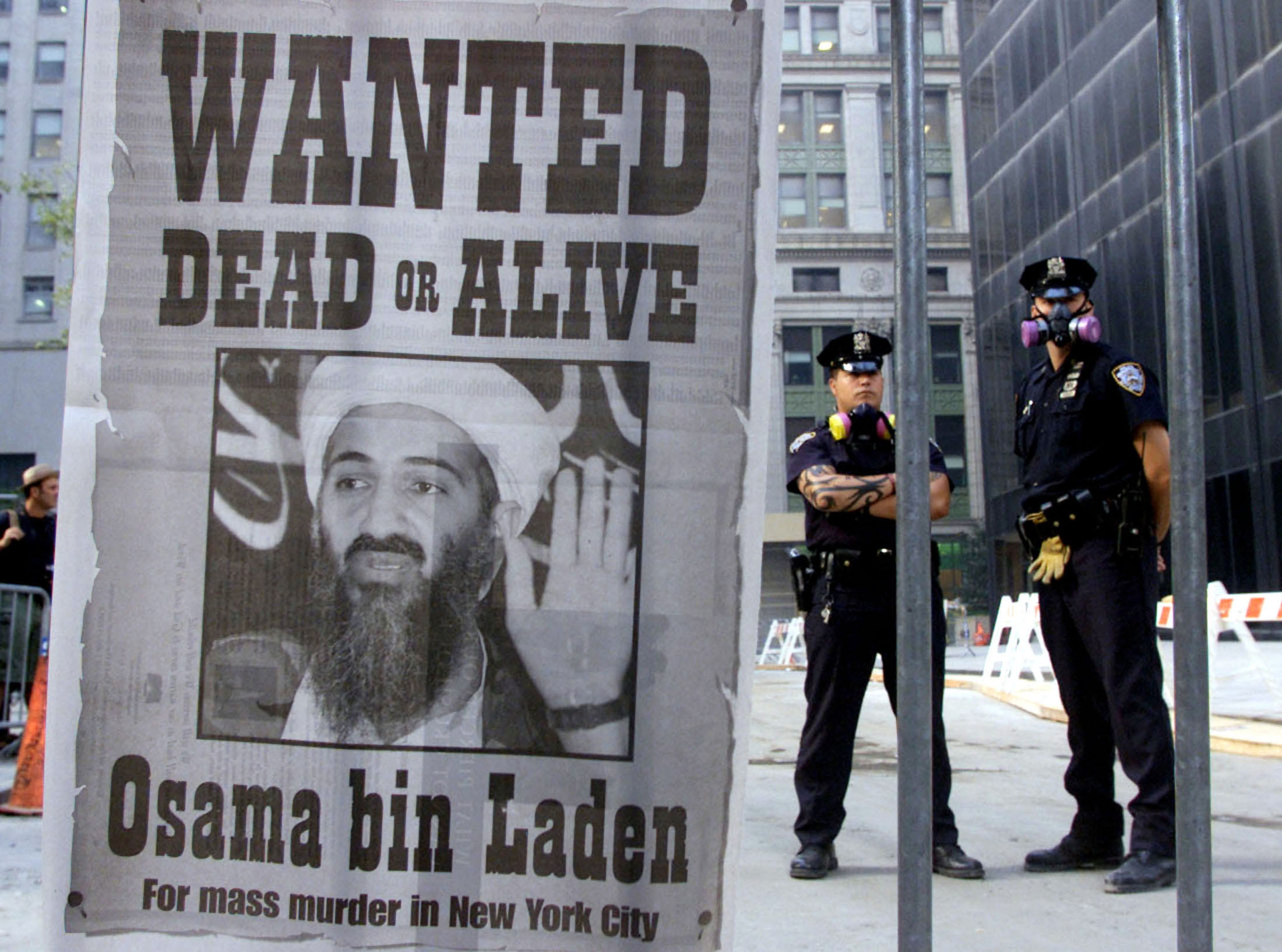 Police officers in New York stand near a full-page wanted poster for Osama bin Laden printed on a newspaper, in this file photo from September 18, 2001. Source: Russell Boyce/Reuters.