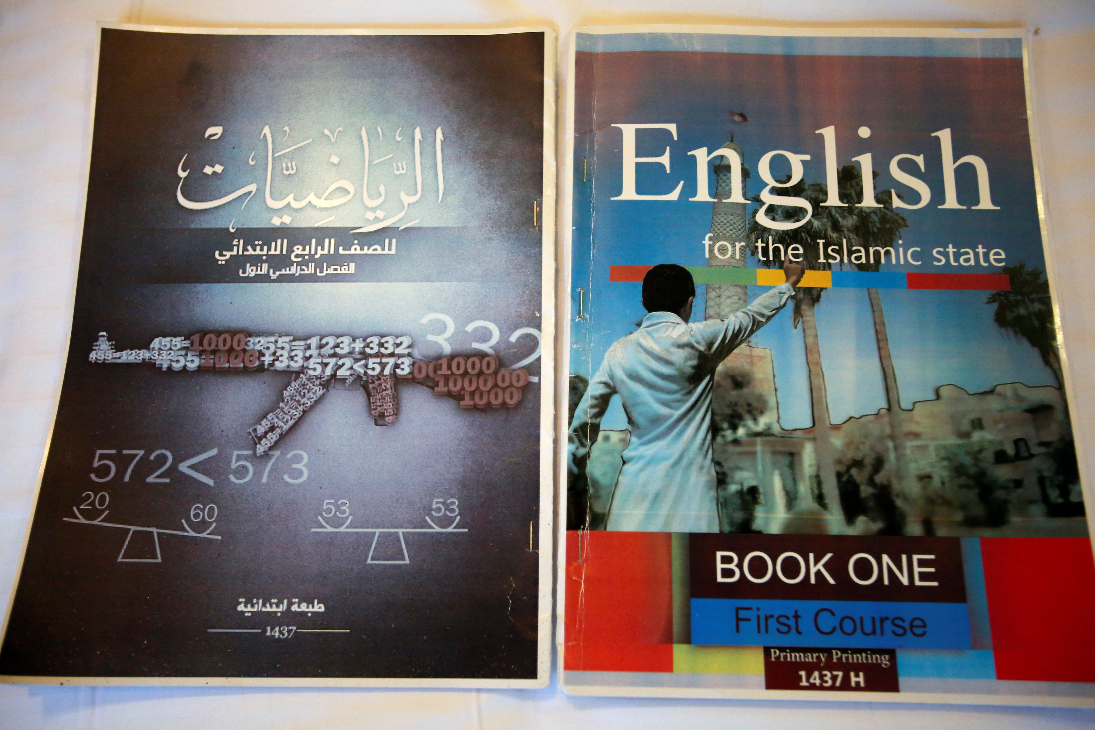 Math and English textbooks, which include military imagery, found in an Islamic State facility for child fighters are pictured in Mosul, Iraq, on February 16, 2017. Source: Khalid al Mousily/Reuters.