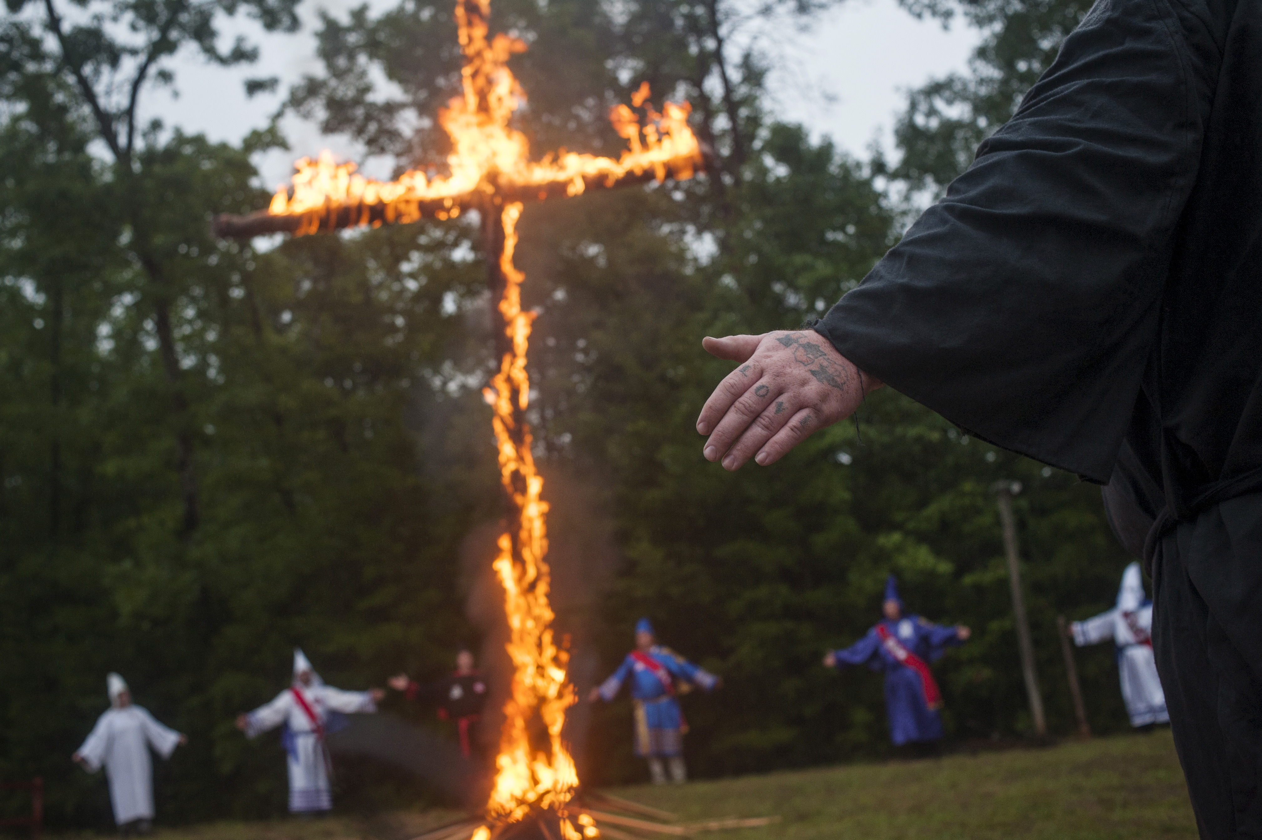 A Klansman with a tattoo on his fingers that reads “Love” participates with members of the Nordic Order Knights and the Rebel Brigade Knights, groups that both claim affiliation with the Ku Klux Klan, in a cross-lighting ceremony on a fellow member’s property in Henry County, Virginia, on August 9, 2014. Source: Johnny Milano/Reuters.