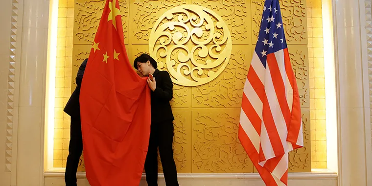 Staff members set up Chinese and U.S. flags for a meeting between Chinese Transport Minister Li Xiaopeng and U.S. Secretary of Transportation Elaine Chao at the Ministry of Transport of China in Beijing on April 27, 2018.