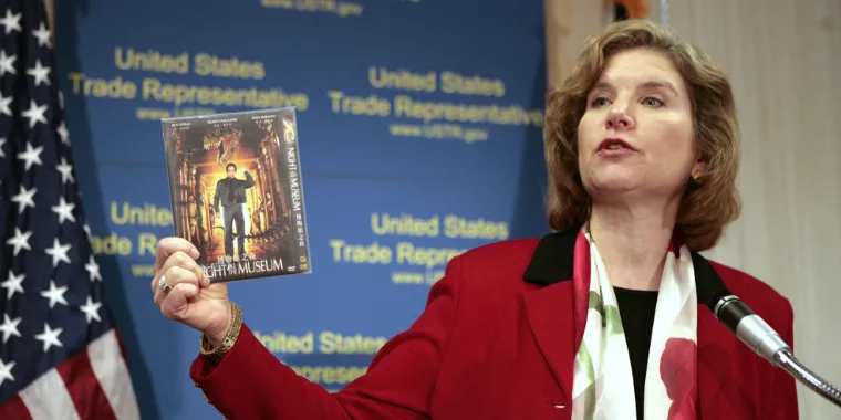 U.S. Trade Representative Susan Schwab holds up a pirated DVD as she talks about two WTO cases against China during a news conference in Washington, DC, on April 9, 2007.