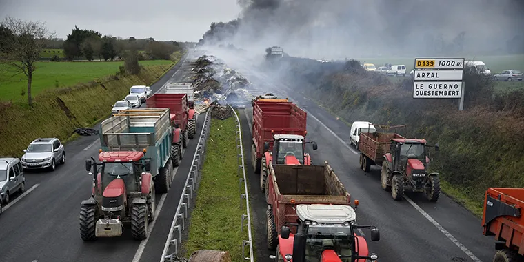 French farmers take part in a blockade on a motorway near Arzal, western France, on January 29, 2016, during a protest against the falling of prices of their products.