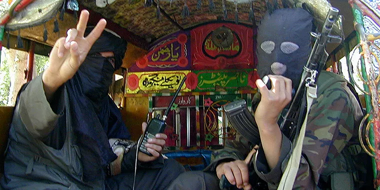 Pakistani Taliban fighters gesture towards the camera before leaving Buner, about 100 km (60 miles) northwest of Islamabad, Pakistan in 2009.