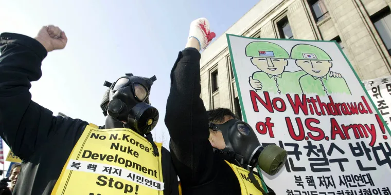 South Korean protesters in gas masks shout anti-North Korean slogans during a rally in Seoul on January 11, 2003, a day after North Korea withdrew from the Treaty on the Nonproliferation of Nuclear Weapons.