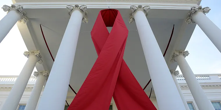 A giant red ribbon hangs from the North Portico of the White House to mark World AIDS Day on December 1, 2013, in Washington.