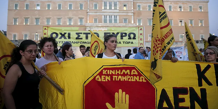 Anti-austerity protesters hold a banner that reads “ ‘I Don’t Pay’ Movement” in Greek during a rally in front of the parliament building in Athens on July 22, 2015.