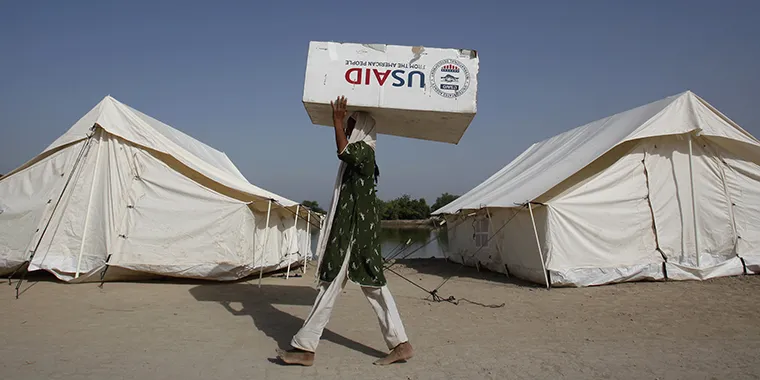 A woman displaced by floods uses a box from the U.S. Agency for International Development to move her belongings in Dadu, Pakistan, on October 10, 2010. 