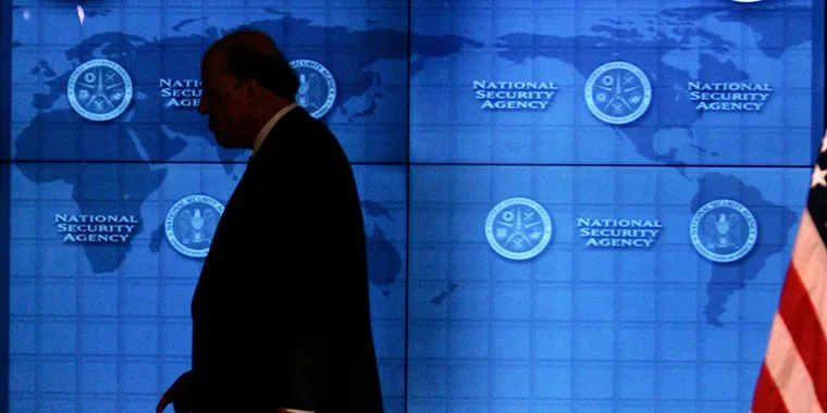 The U.S. national intelligence director walks past a video screen at Fort Meade, Maryland, on January 25, 2006.