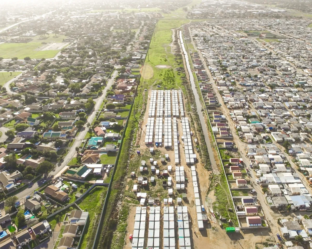 A photo showing a strip of land and fencing separating the wealthy neighborhood Strand from the poorer neighborhoods of Nomzamo and Lwandle in Cape Town, South Africa, on April 23, 2016.