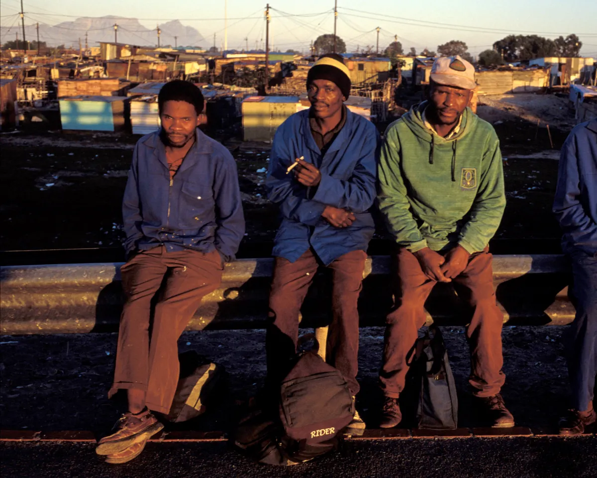 A photo shows unemployed men waiting to get hired for a day of work on August 10, 2001 in a township outside Cape Town, South Africa.