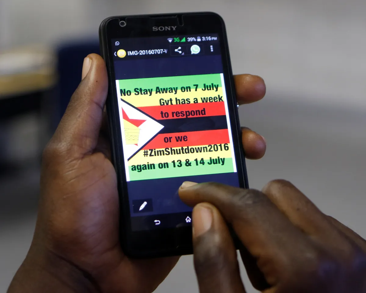 A photo showing a man in Harare, Zimbabwe, receiving updates on his phone about a strike protesting the country's President Robert Mugabe on July 7, 2016.
