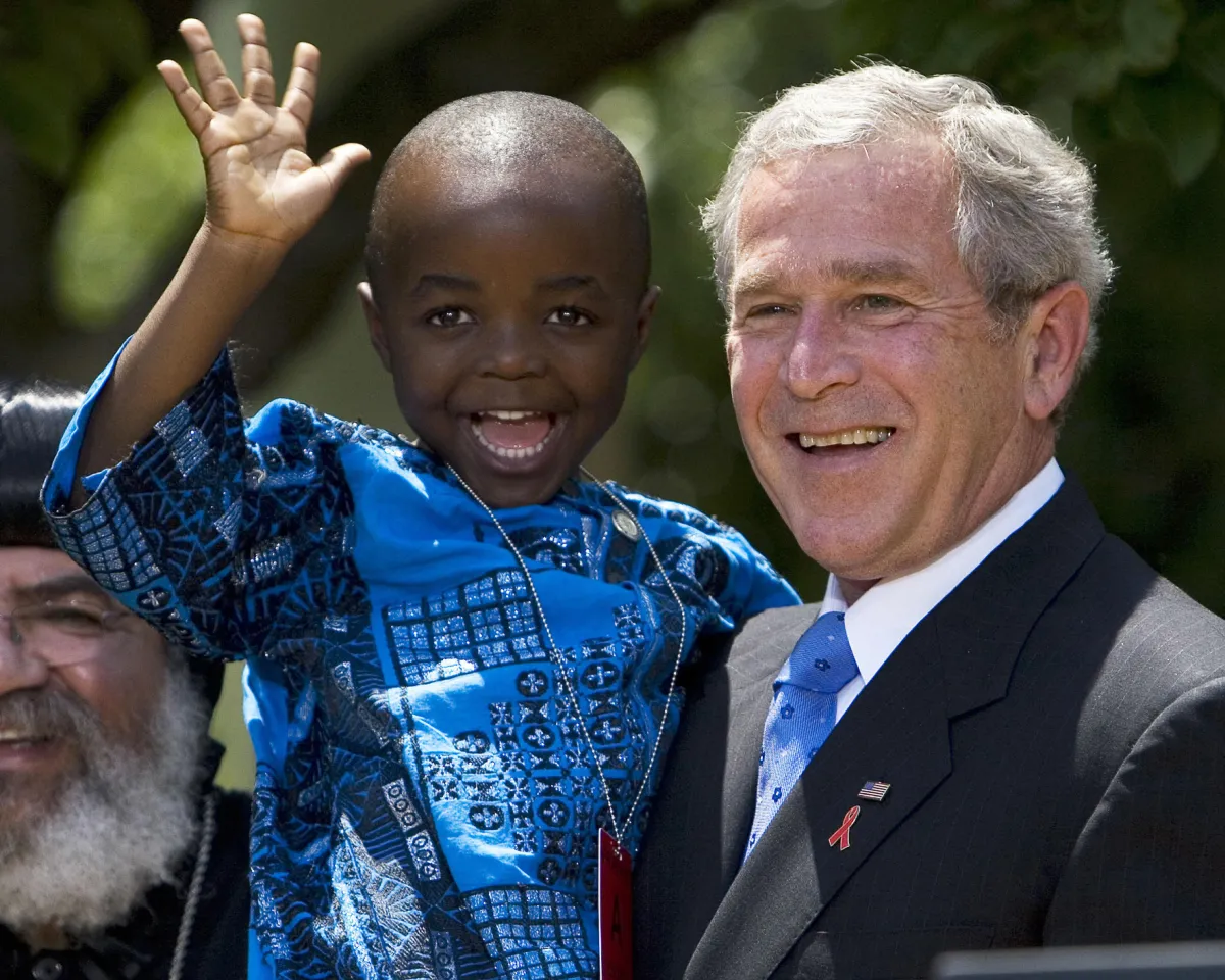 A photo showing U.S. President George W. Bush posing with 4-year-old Baron Mosima Loyiso Tantoh, whose mother suffers from AIDS, after delivering a statement on PEPFAR on May 30, 2007, in the White House Rose Garden in Washington, DC.