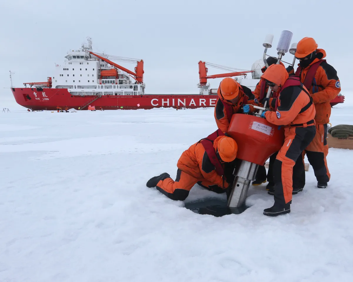 A photo showing Chinese research team setting up oceanography equipment near the icebreaker Xuelong, or 'Snow Dragon", in the Arctic Ocean on August 18, 2016.