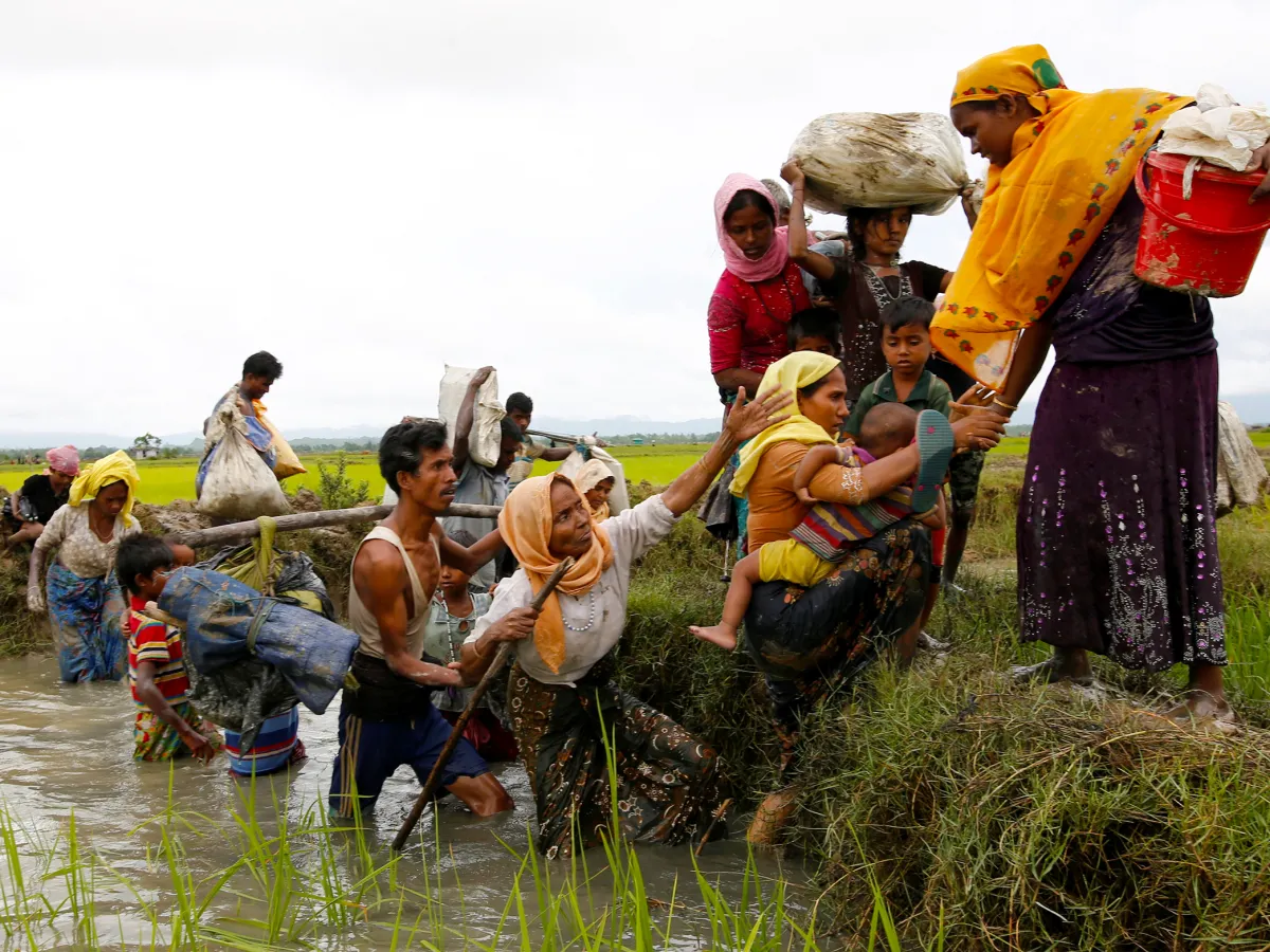 A photo showing Rohingya refugees crossing a canal after travelling over the Bangladesh-Myanmar border in Teknaf, Bangladesh on September 1, 2017.