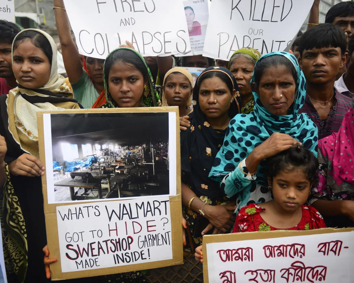 A photo showing relatives of Bangladeshi workers who lost their lives in a garment factory disaster gathering with banners in Savar, Bangladesh, on June 29, 2013.