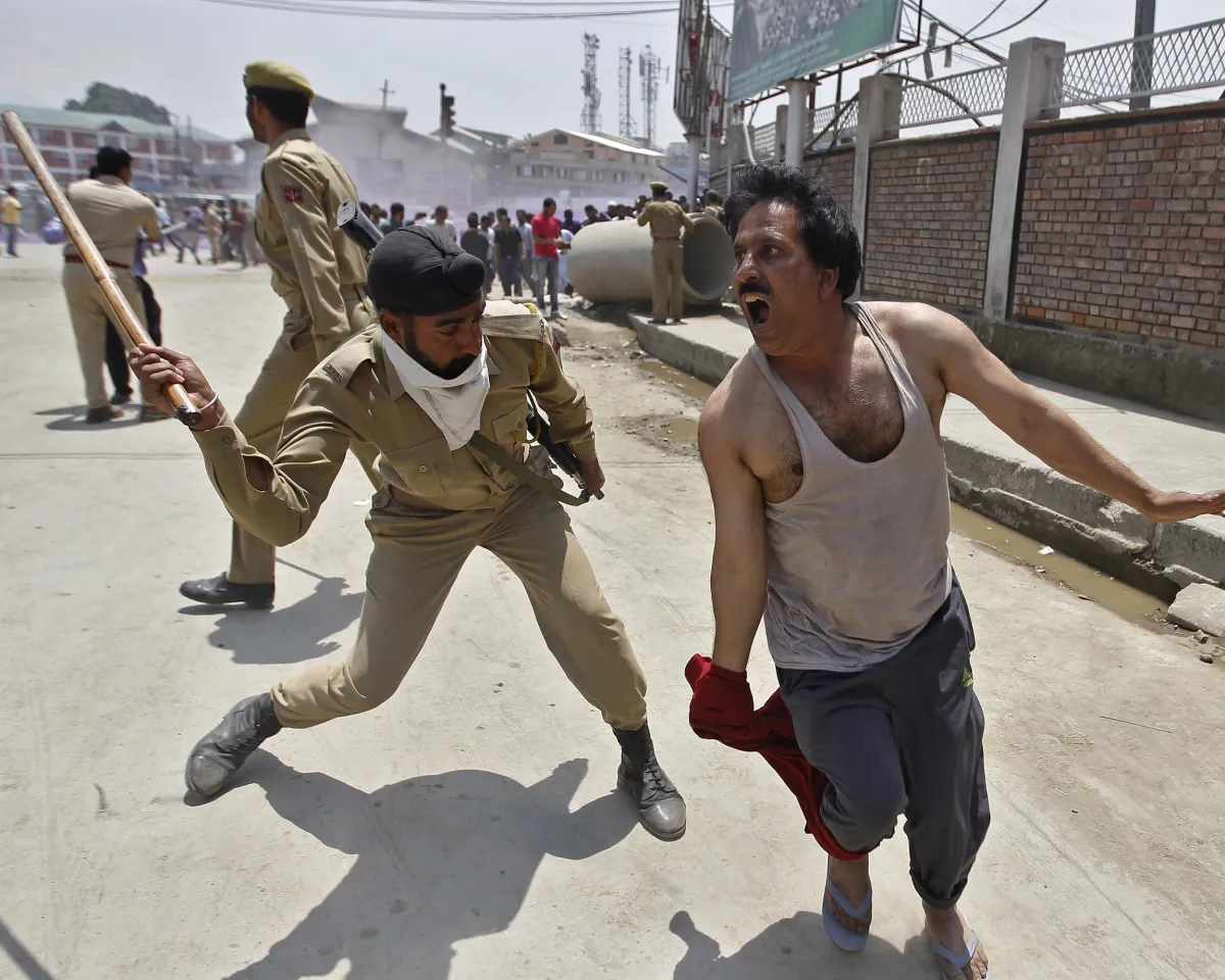 A photo of an Indian policeman using a baton to disperse a protester during a demonstration against the government in Srinagar, Kashmir, on May 28, 2015.
