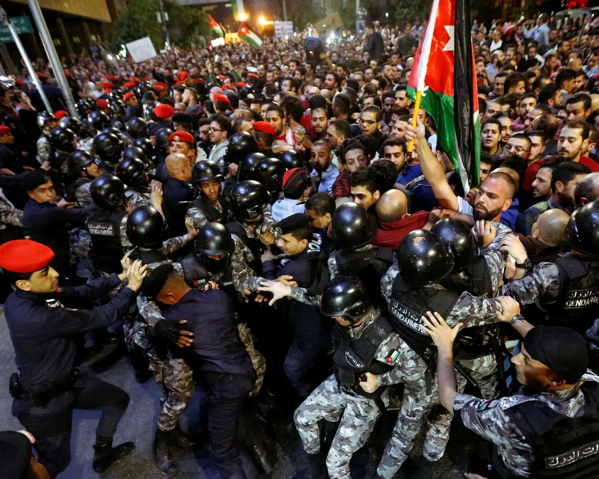 A photo showing policemen clashing with a crowd protesting tax hikes in Amman, Jordan, on June 3, 2018.