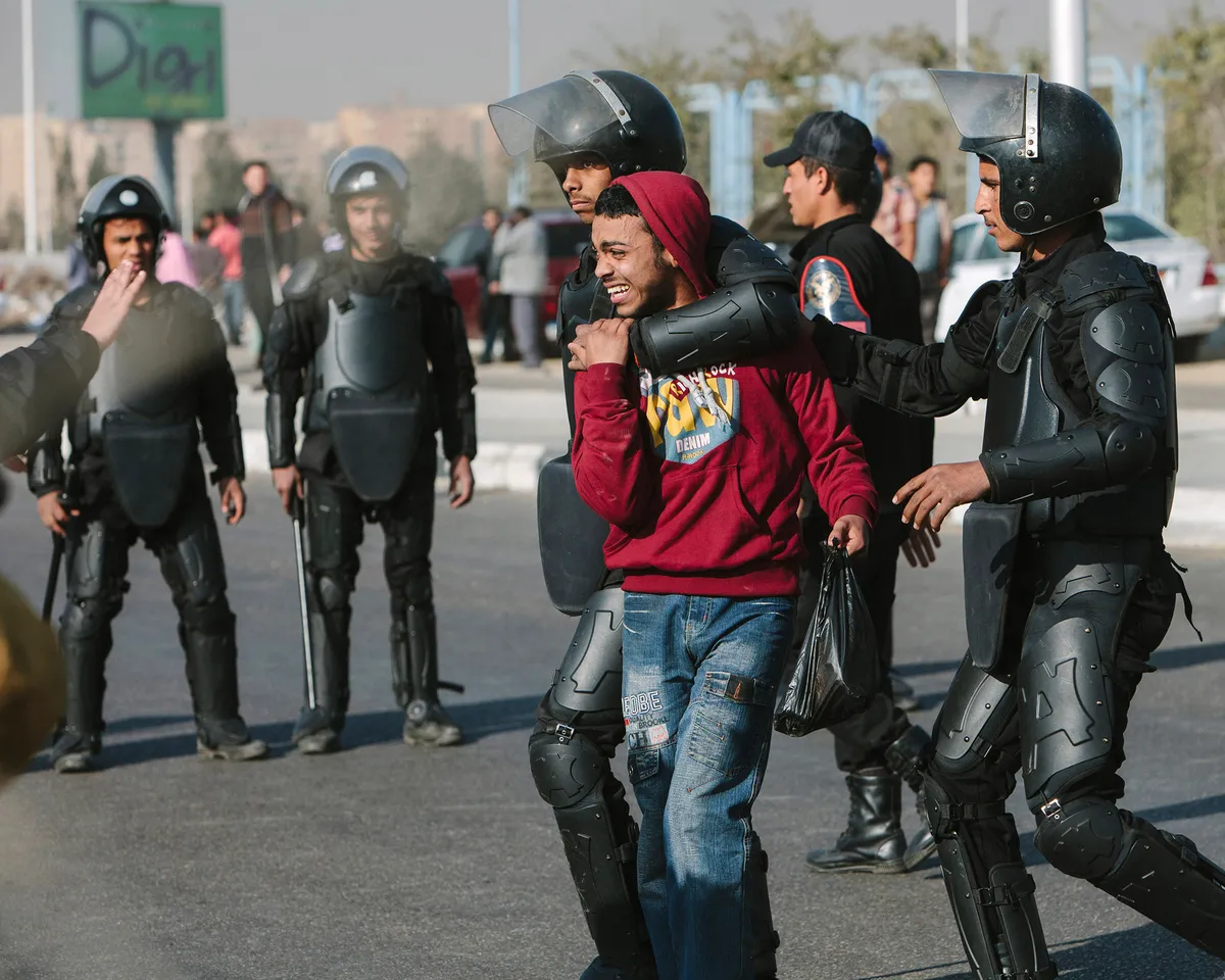 A photo showing Muslim Brotherhood supporter being arrested by Egyptian riot police after a protest prior to the planned trial of deposed President Mohammed Morsi on January 8, 2014 in Cairo, Egypt.