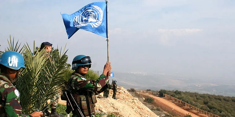 An Indonesian peacekeeper waves a UN flag on the border between Lebanon and Israel in the southern Lebanese village of Adaisseh on November 30, 2009.