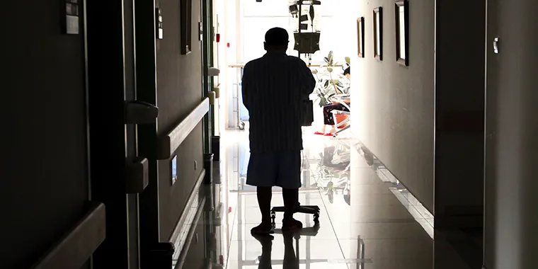 A cancer patient pushes his drip stand as he walks down the hallway of the Beijing Cancer Hospital on July 12, 2011.