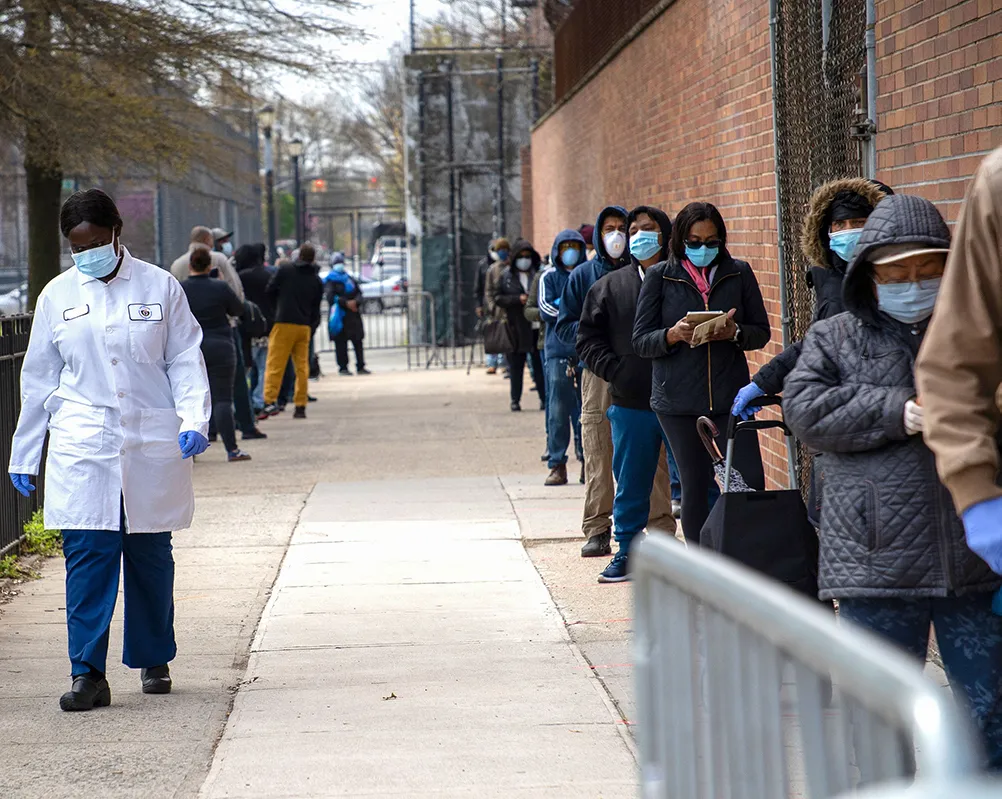 A photo showing people wearing face masks as a preventive measure lining up at one of New York City's new testing tents outside Gotham Health in East New York amid the coronavirus outbreak.