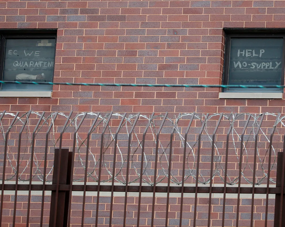 A photo showing the words "help no-supply" written on a window at the Cook County Department of Corrections (CCDOC), housing one of the nation's largest jails, in Chicago, Illinois, on April 9, 2020.