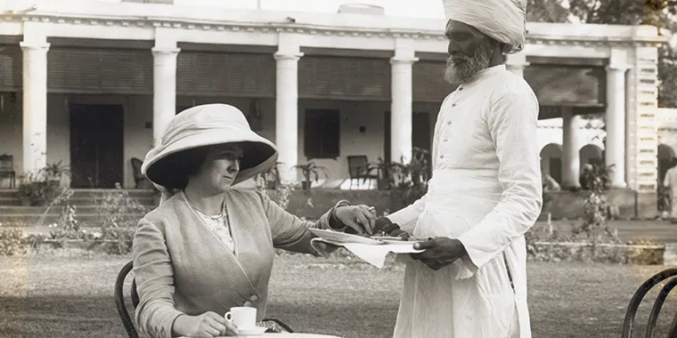 A Hindu servant serves tea to a European colonial woman in this undated photograph.