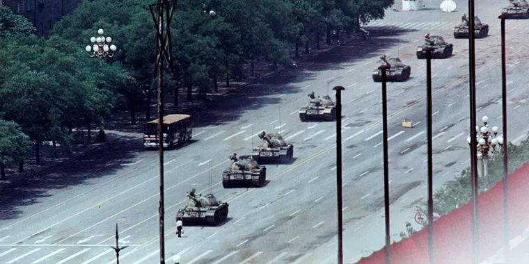 A Beijing resident stands in front of tanks on the Avenue of Eternal Peace during the crushing of the Tiananmen Square uprising on June 5, 1989.