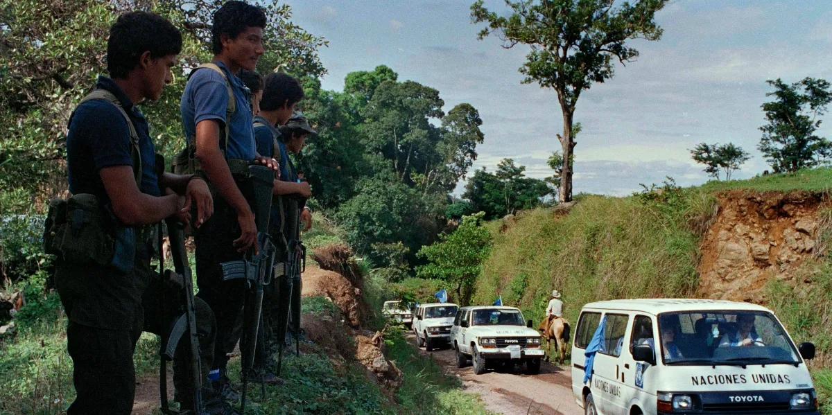FMLN rebel guerrillas line up along a road in the conflictive zone of Chalatenango to welcome the first United Nations observers in the rebel controlled area, in San Jose Las Flores, El Salvador, Aug. 30, 1991. 