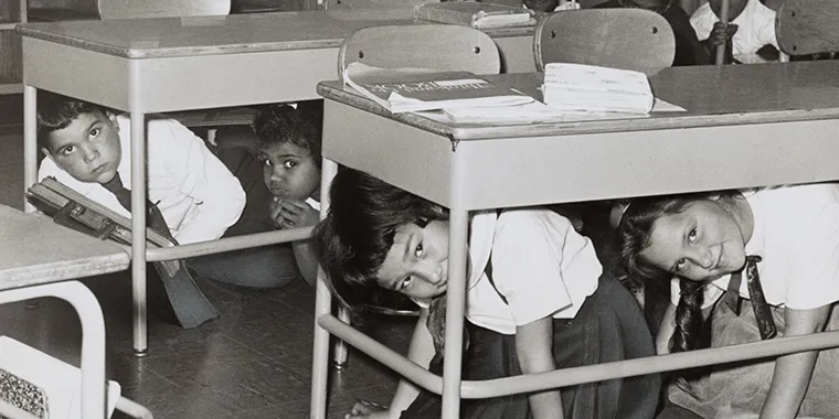 Students at a Brooklyn middle school have a "duck and cover" practice drill in preparation for a nuclear attack in 1962.
