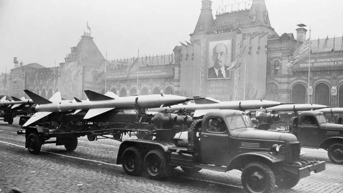 Military trucks pull trailers of short-range, two-stage missiles with twin tail assembly past the Kremlin in 1957.