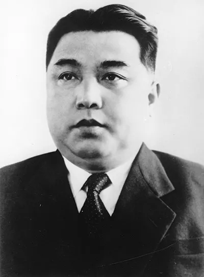 Black and white portrait photo of Kim Il Sung wearing a suit and tie.