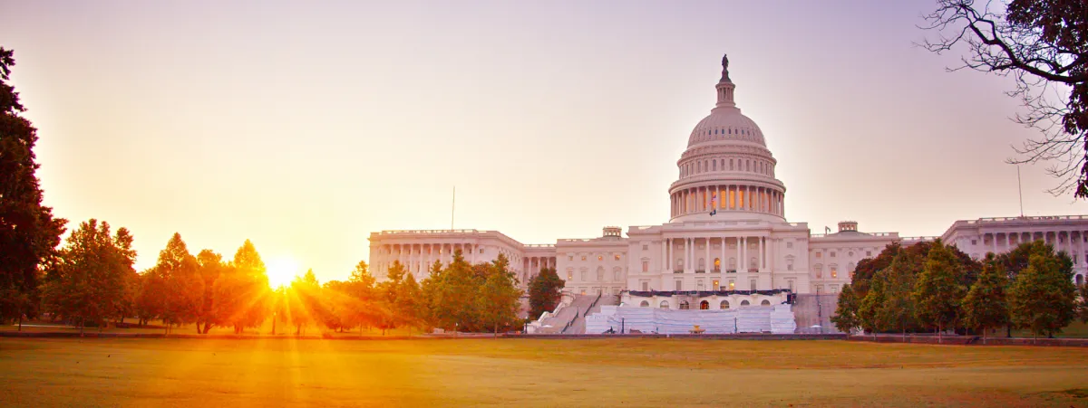 The sun rises behind the U.S. Capitol building.