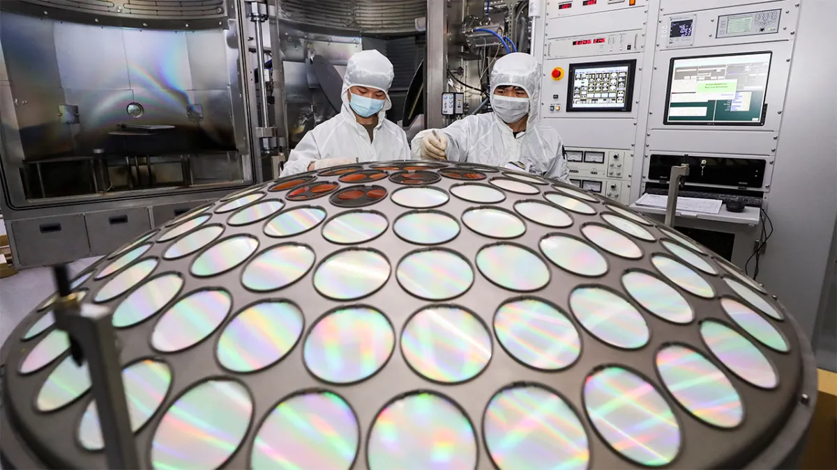 Two employees work on the production of LED epitaxial wafer at a Semiconductor manufacturing factory in China