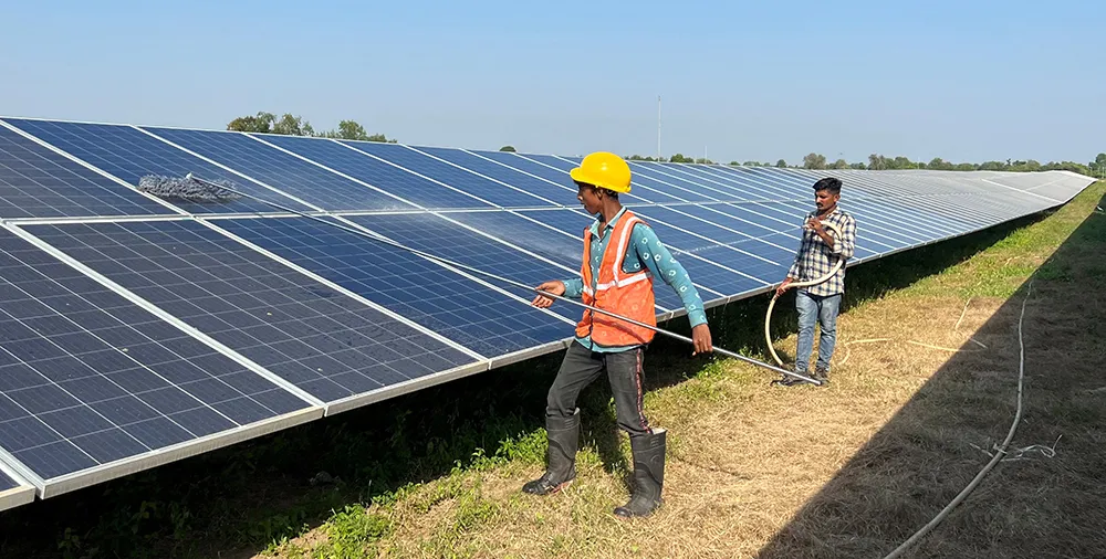 Indian workers clean solar panels