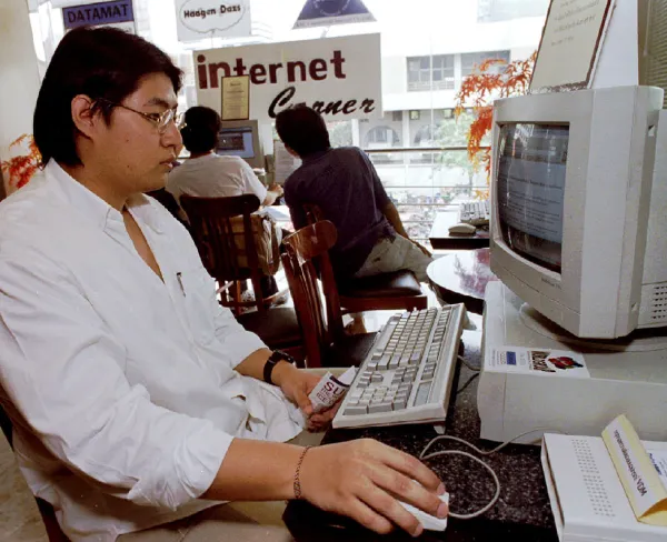 A Thai university student surfs the internet at an ice cream shop in Bangkok on February 8, 1996.