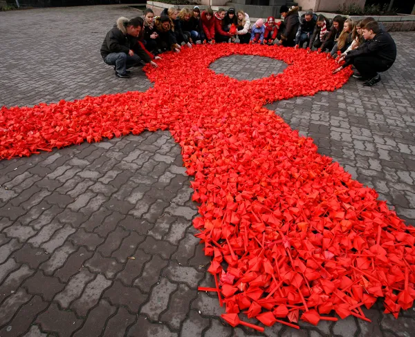 Activists of "Young medics of Russia" social organization and city volunteers form a red ribbon, the symbol of the worldwide campaign against AIDS, made from paper tulips as they take part in the campaign and also mark International Volunteers' Day in the city of Rostov-on-Don, December 5, 2010. 