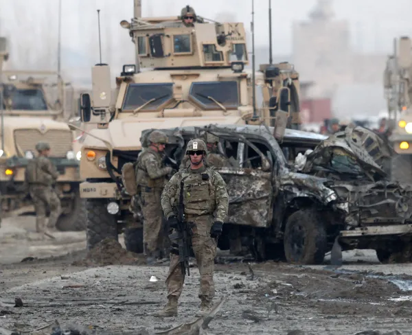 U.S. troops stand guard at the site of a suicide car bomb attack in Kabul, on February 10, 2014.