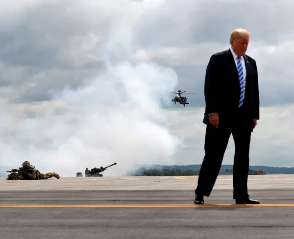 U.S. President Donald Trump observes a demonstration with U.S. Army 10th Mountain Division troops, an attack helicopter, and artillery as he visits Fort Drum, New York, on August 13, 2018.