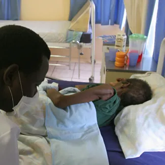A patient is nursed at a hospice partially funded by the President's Emergency Plan for AIDS Relief (PEPFAR) in White River Junction, South Africa, on December 15, 2008. 