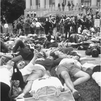 Protesters participate in a "die-in" at the National Institutes of Health campus during the "Storm the NIH" protest in Bethesda, Maryland on May 21, 1990. The protesters blew whistles and sounded horns every twelve minutes to symbolize the death rate of AIDS victims at the time: one AIDS-related death every twelve minutes in the United States.