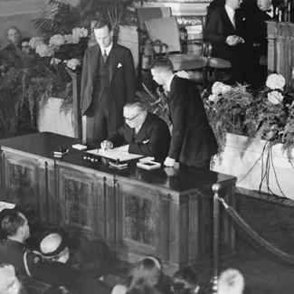 British Foreign Secretary Ernest Bevin signs the North Atlantic Treaty in Washington while Sir Oliver Franks, the British ambassador to the United States, watches on April 4, 1949.