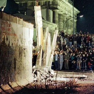 A big section of the Berlin Wall is lifted by a crane as East Germany starts to dismantle the wall near the Brandenburg Gate in East Berlin on February 20, 1990.