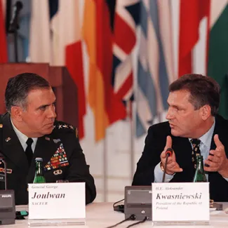 Polish President Aleksander Kwasniewski (right) makes a point during his speech at the 14th international NATO Workshop on Political-Military Decision Making at Prague Castle on June 22, 1997, while General George Joulwan, the supreme commander of allied forces in Europe, listens.