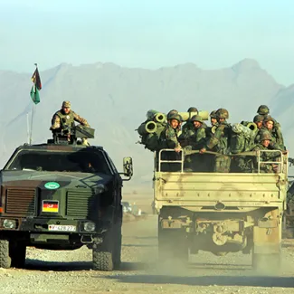 An Afghan army truck (right) drives beside a NATO-led International Security Assistance Force vehicle outside of Kabul on December 17, 2004.