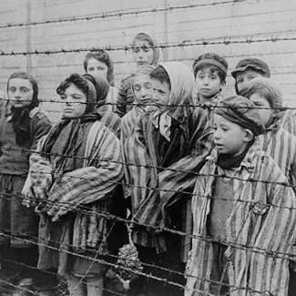 A group of child survivors behind a barbed wire fence at the Nazi concentration camp at Auschwitz-Birkenau in southern Poland, on the day of the camp’s liberation by the Red Army on January 27, 1945.
