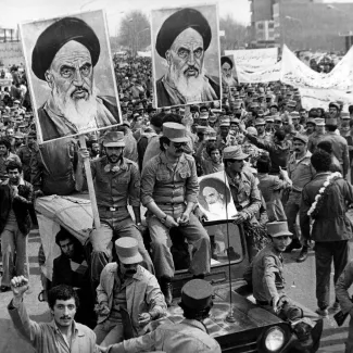 The Iranian Islamic Republic Army demonstrates in solidarity with people in the street during the Iranian revolution. They are carrying posters of the Ayatollah Khomeini, the Iranian religious and political leader.