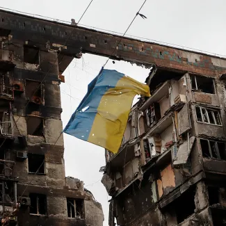 Ukrainian flag hangs between two bombed out buildings in war-torn Mariupol, Ukraine.