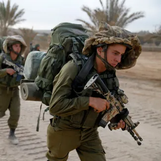 On August 2, 2014, Israeli soldiers walk outside the Gaza Strip on their way into the area as part of an offensive against Palestinian militants.